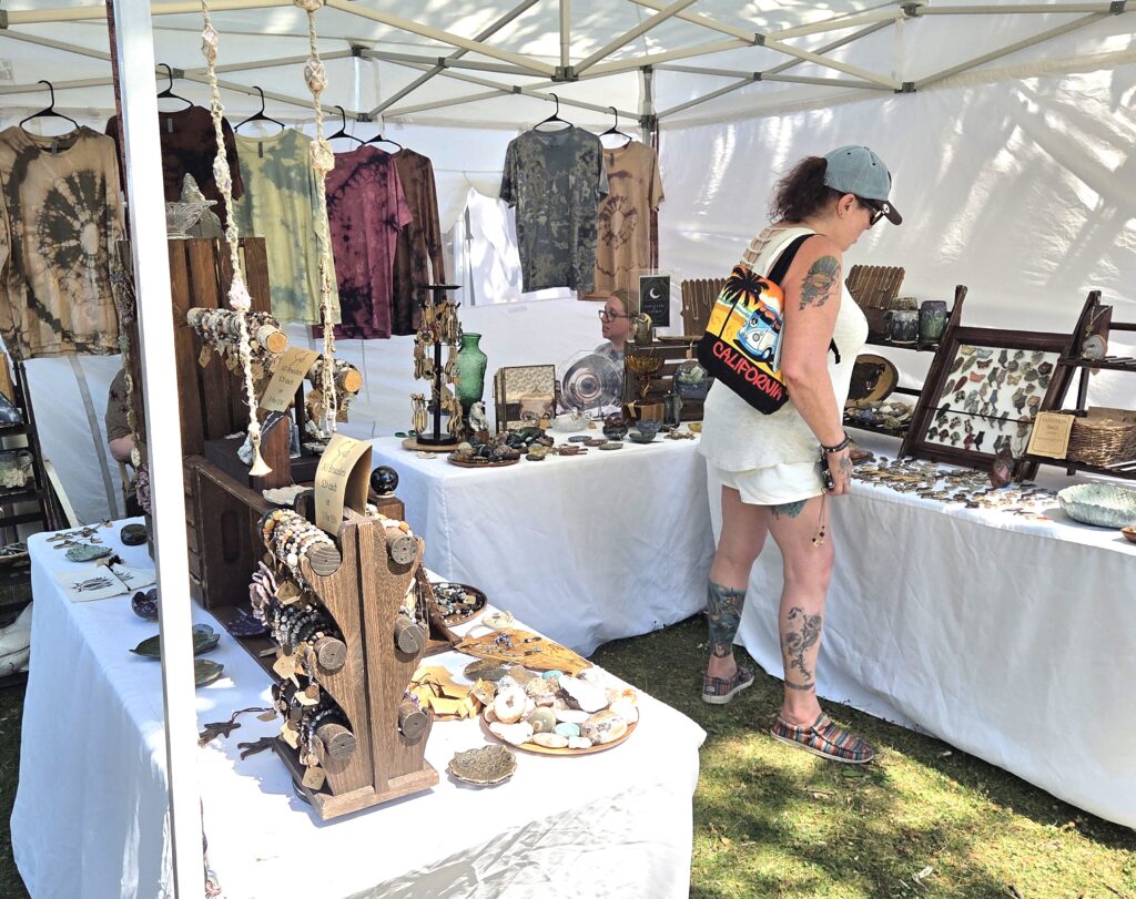Shopper finds treasures at an Art in the Park vendor booth