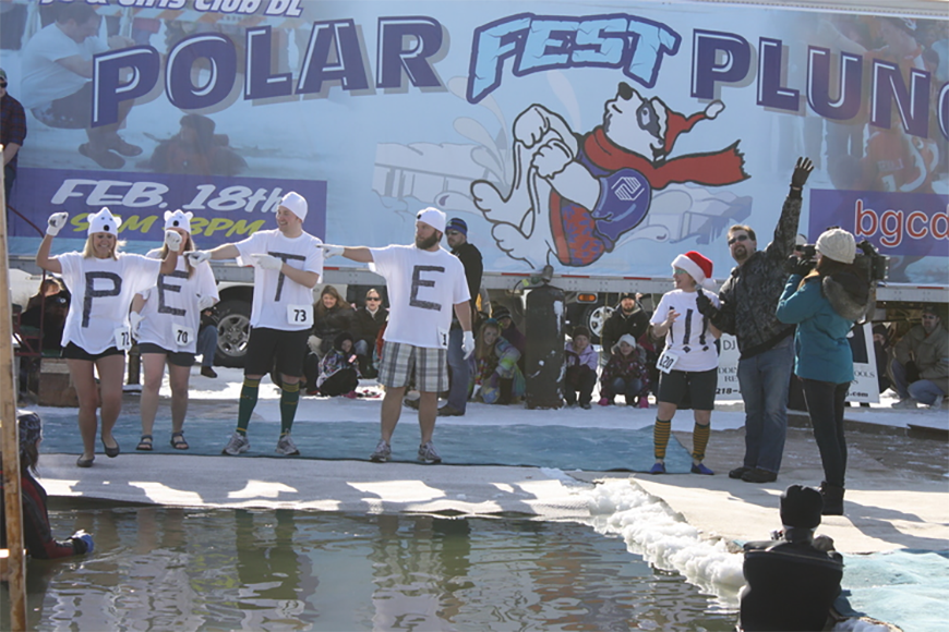 people standing on edge of hole cut in ice for Polar Plunge