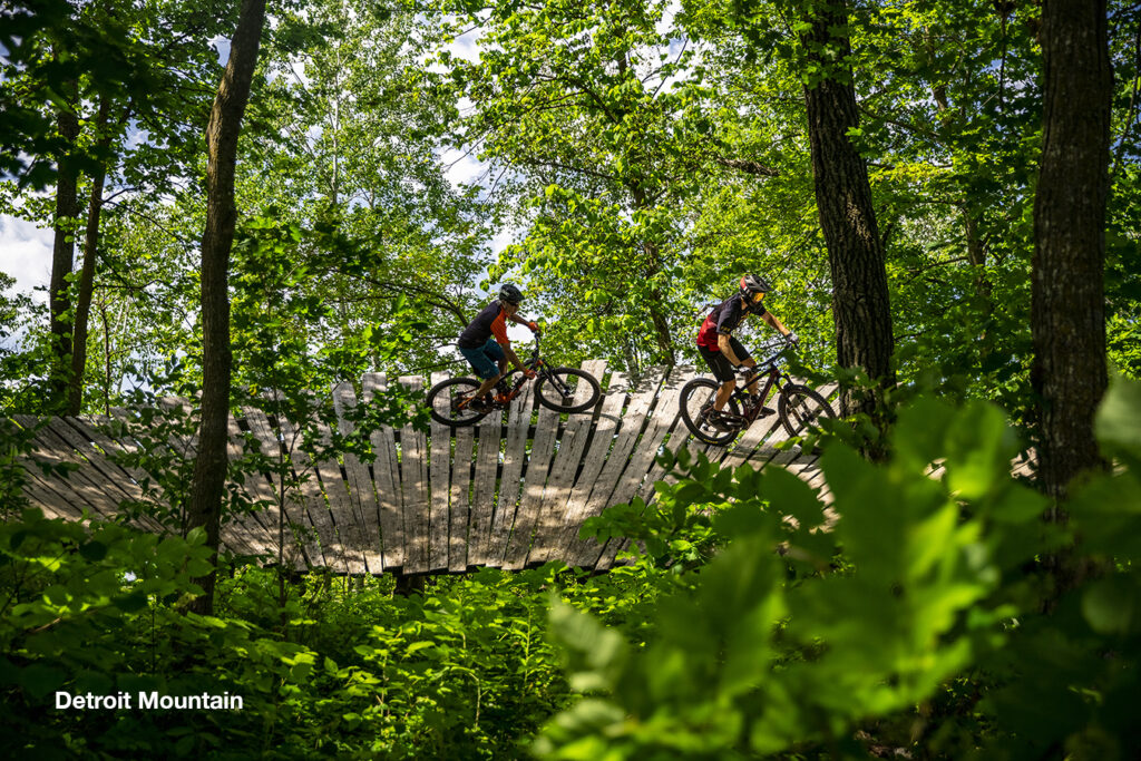 Two mountain bikers riding wooden berms