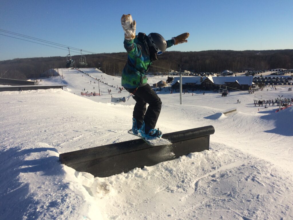 snowboarder gliding over a rail