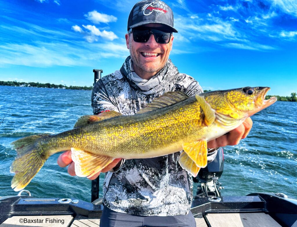 Guy with big smile holding walleye he caught fishing