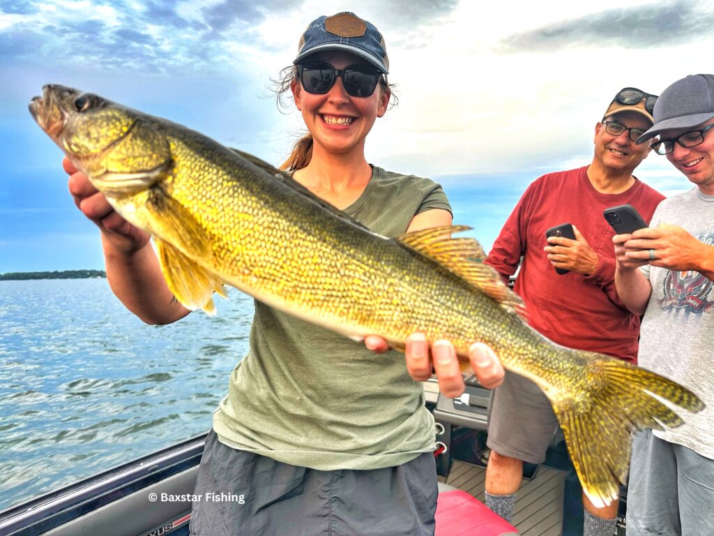 Gal in boat showing walleye she caught fishing