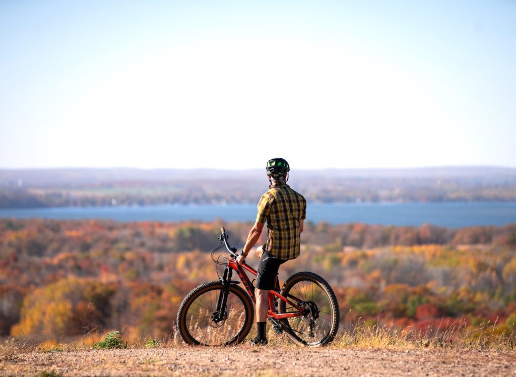 mountain biker at Detroit Mountain summit overlooking fall leaf colors and Detroit Lake in background