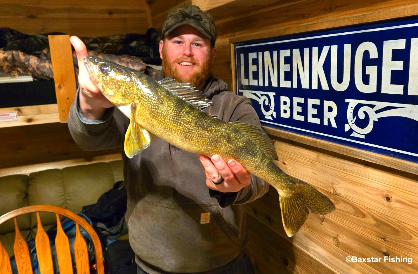 Man holding nice walleye caught inside ice fishing house