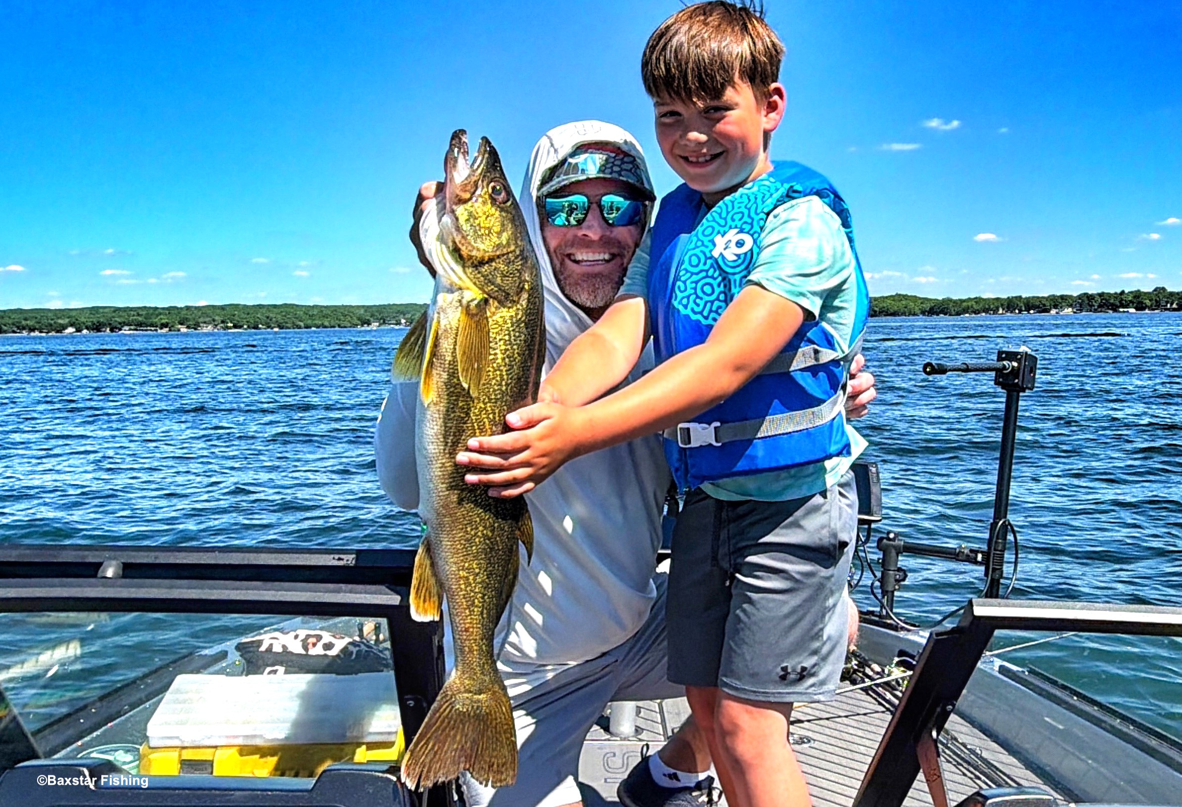 man and boy holding walleye caught in boat fishing